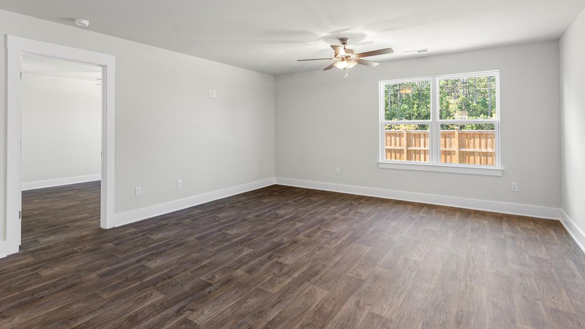 The open-concept family room, kitchen, and dining area feature granite countertops, stainless steel appliances, including a smooth-top range, dishwasher and overhead microwave.