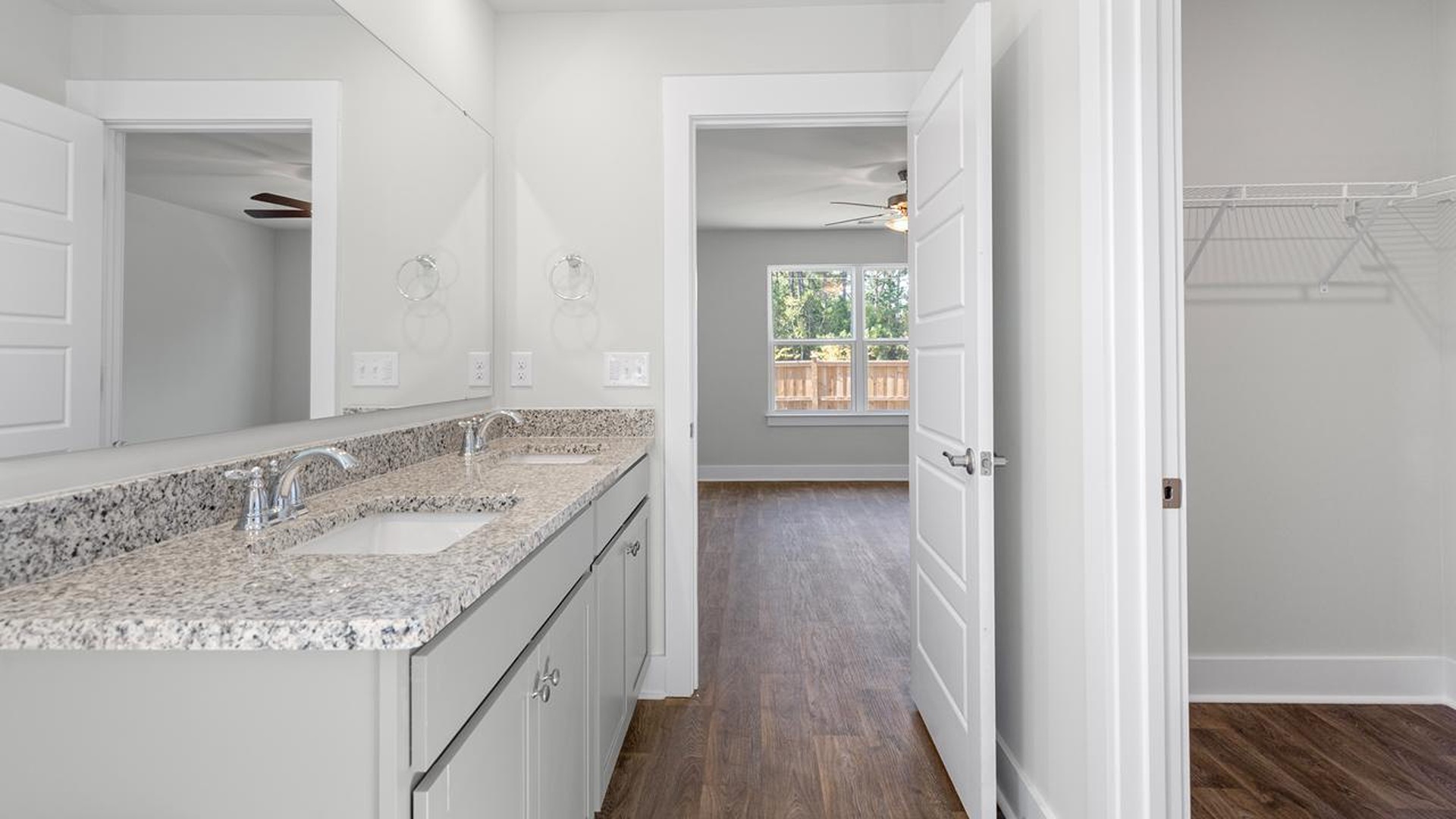 At the back, the primary suite provides privacy with a large walk-in closet and walk-in shower. This floor plan combines comfort and convenience, making it a great choice for those seeking an open layout and a 2-car garage.