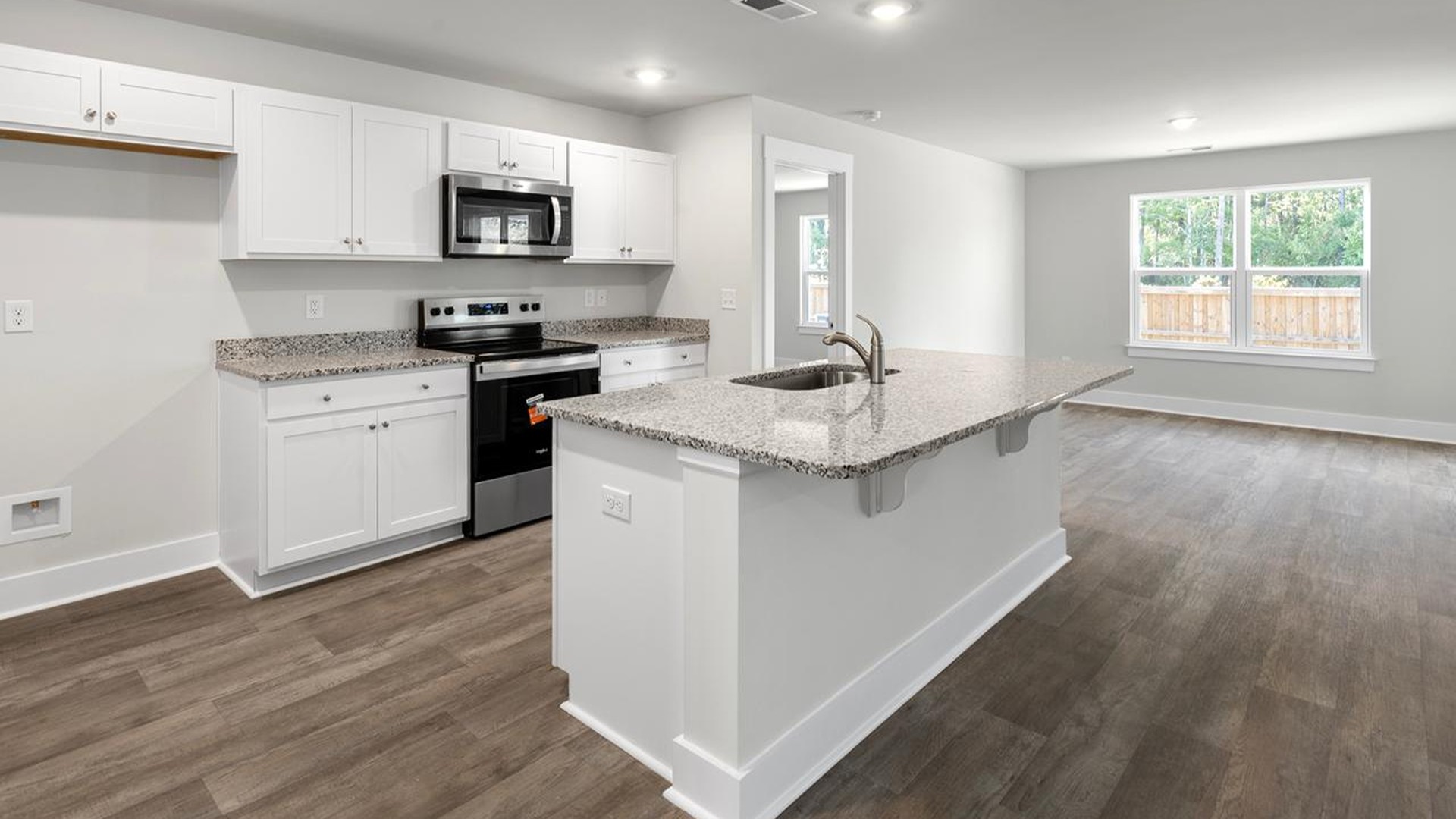 The kitchen features a large island, granite countertops, and stainless-steel appliances, which are sure to both turn heads and make meal prep easy.