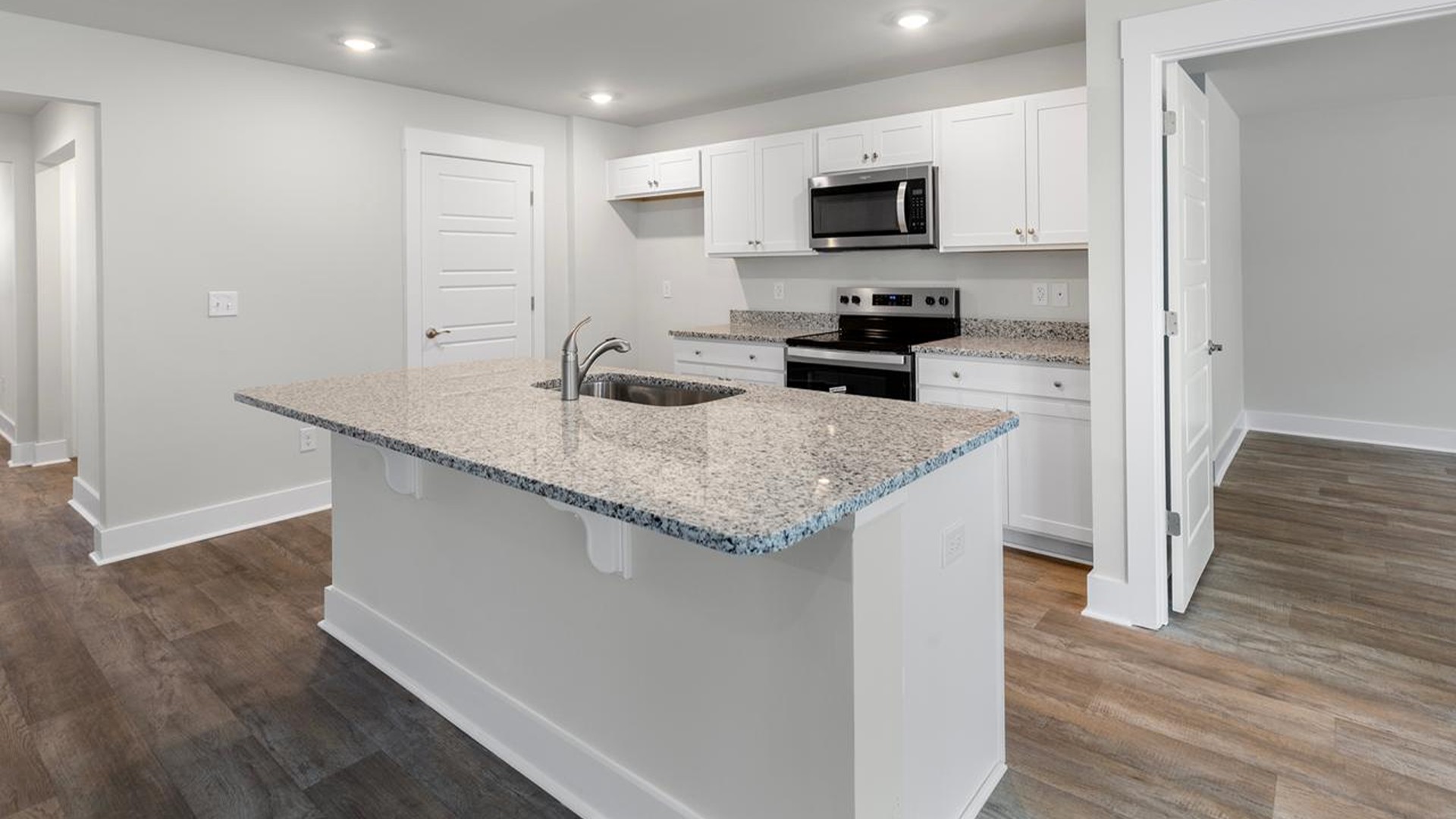 The kitchen features a large island, granite countertops, and stainless-steel appliances, which are sure to both turn heads and make meal prep easy.