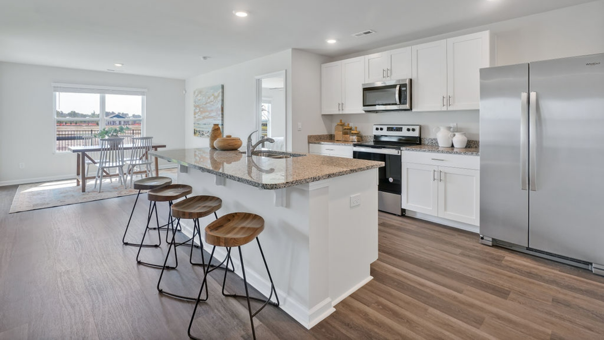 The kitchen features a large island, granite countertops, and stainless-steel appliances, which are sure to both turn heads and make meal prep easy. You’ll never be too far from the action with the living and dining area right there.