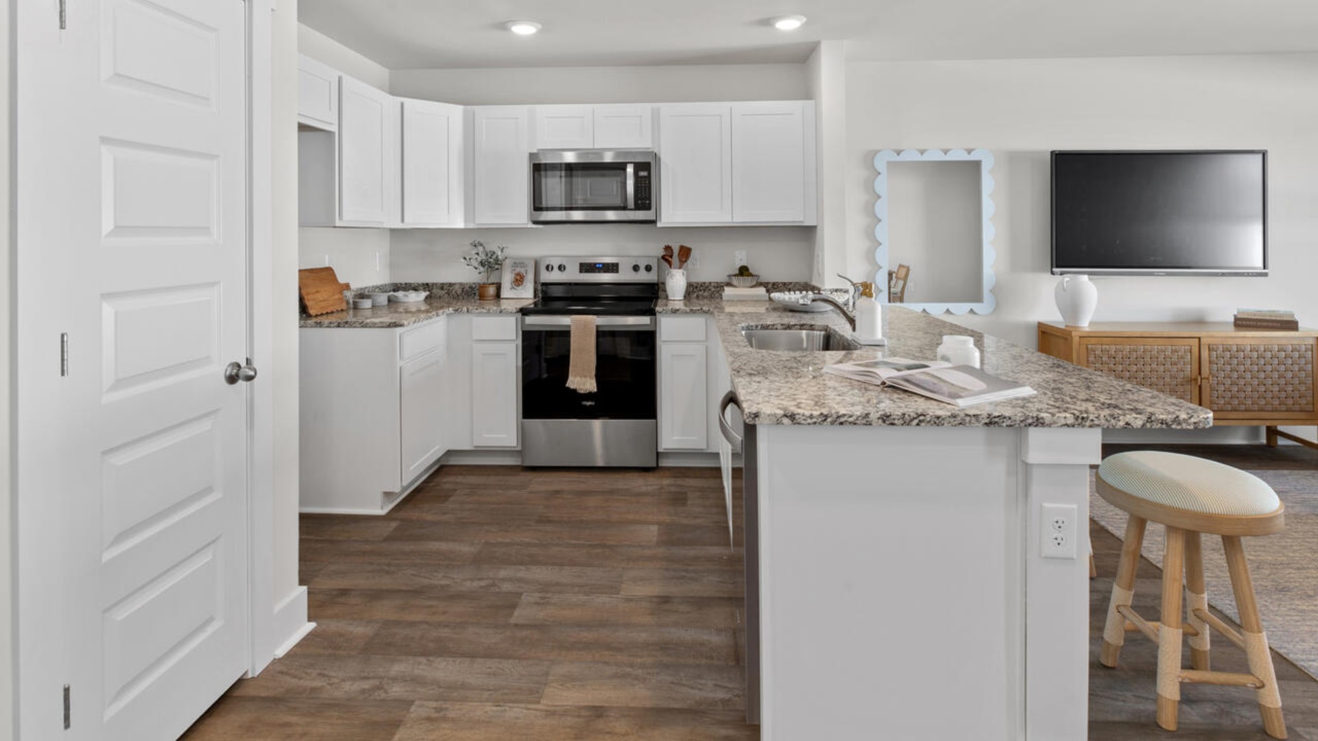 The kitchen overlooks the dining and living spaces and is equipped with stainless-steel appliances and granite countertops, making it easy to stay connected while preparing meals