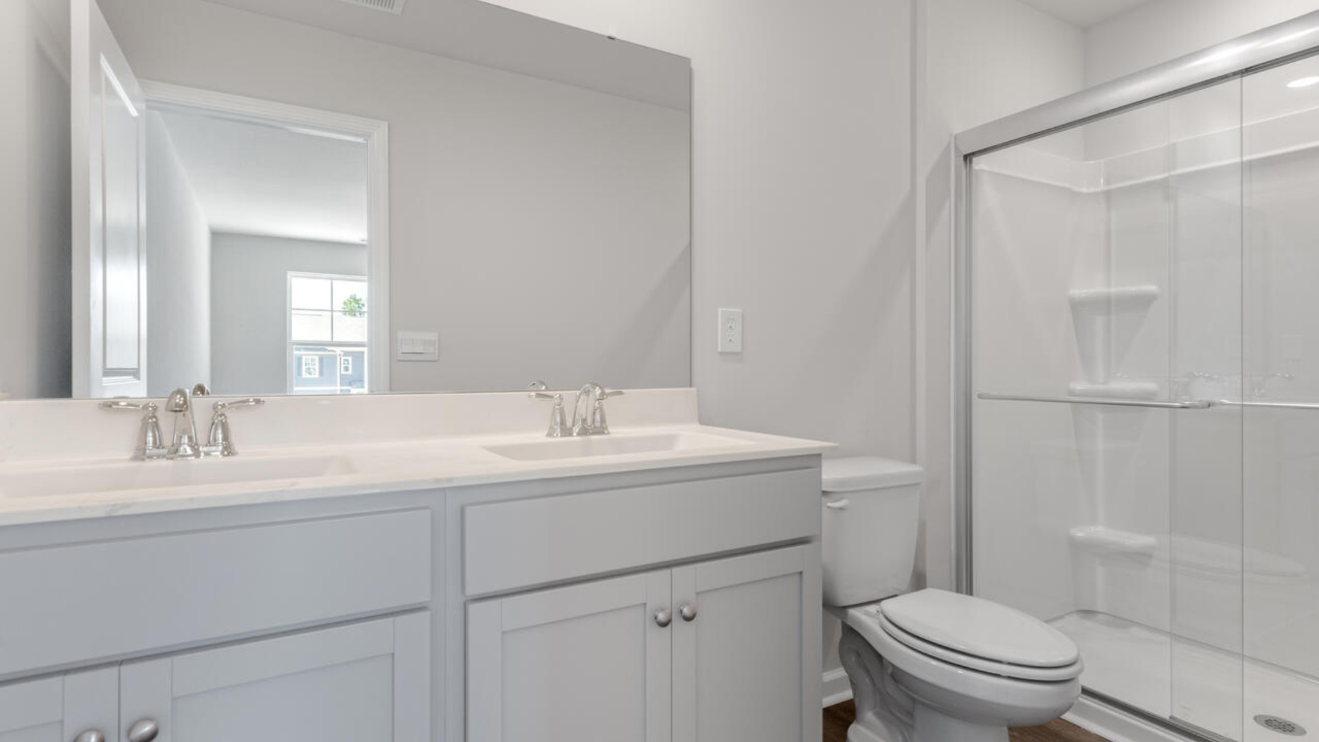 The second floor features the primary bedroom with a walk-in closet and double vanities. It also includes two additional bedrooms, a shared bathroom, and a laundry room for convenience.