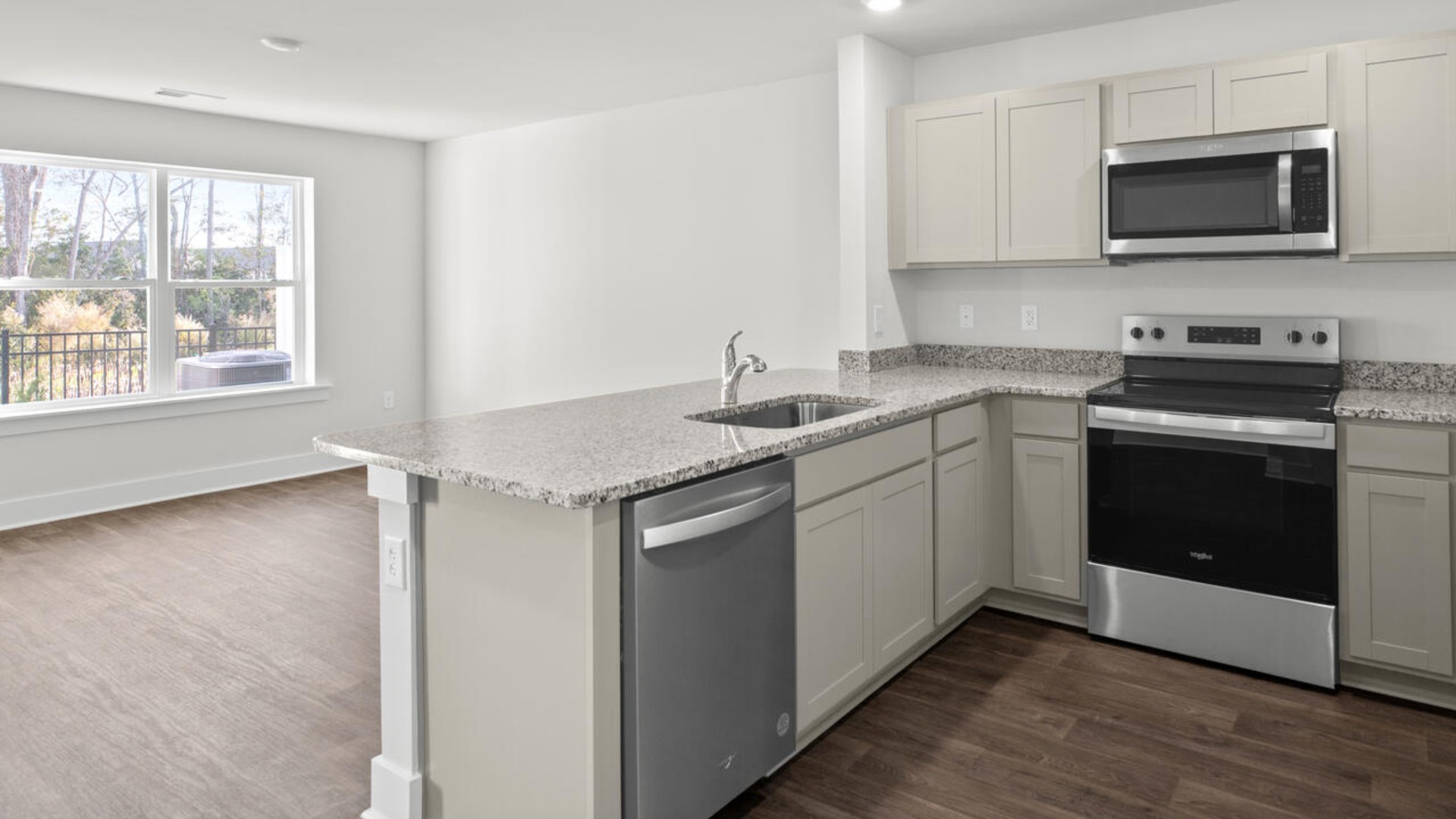 The kitchen overlooks the dining and living spaces and is equipped with stainless-steel appliances and granite countertops, making it easy to stay connected while preparing meals.