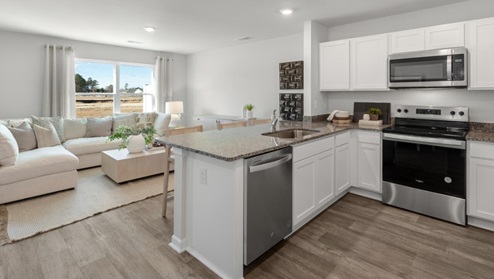 The kitchen overlooks the dining and living spaces, ideal for entertaining guests or enjoying family time while preparing meals with new stainless-steel appliances and Granite countertops.
