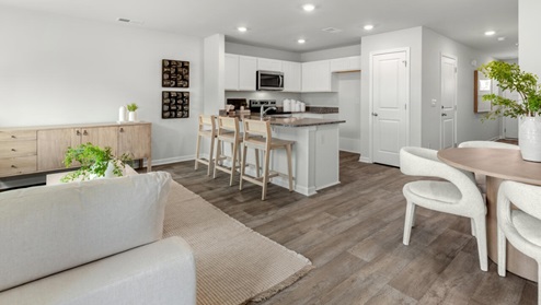 The kitchen overlooks the dining and living spaces, ideal for entertaining guests or enjoying family time while preparing meals with new stainless-steel appliances and Granite countertops.