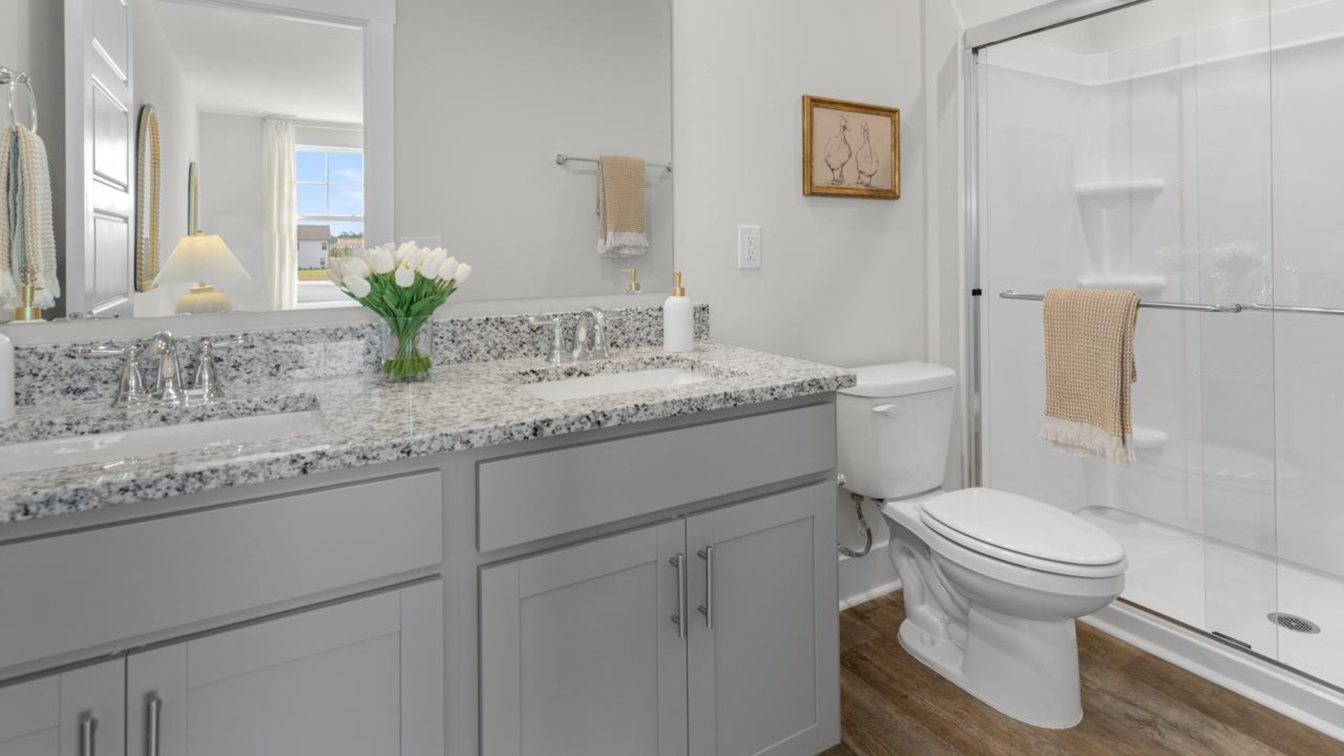 The second floor features the primary bedroom with a walk-in closet and double vanities. It also includes two additional bedrooms, a shared bathroom, and a laundry room for convenience.