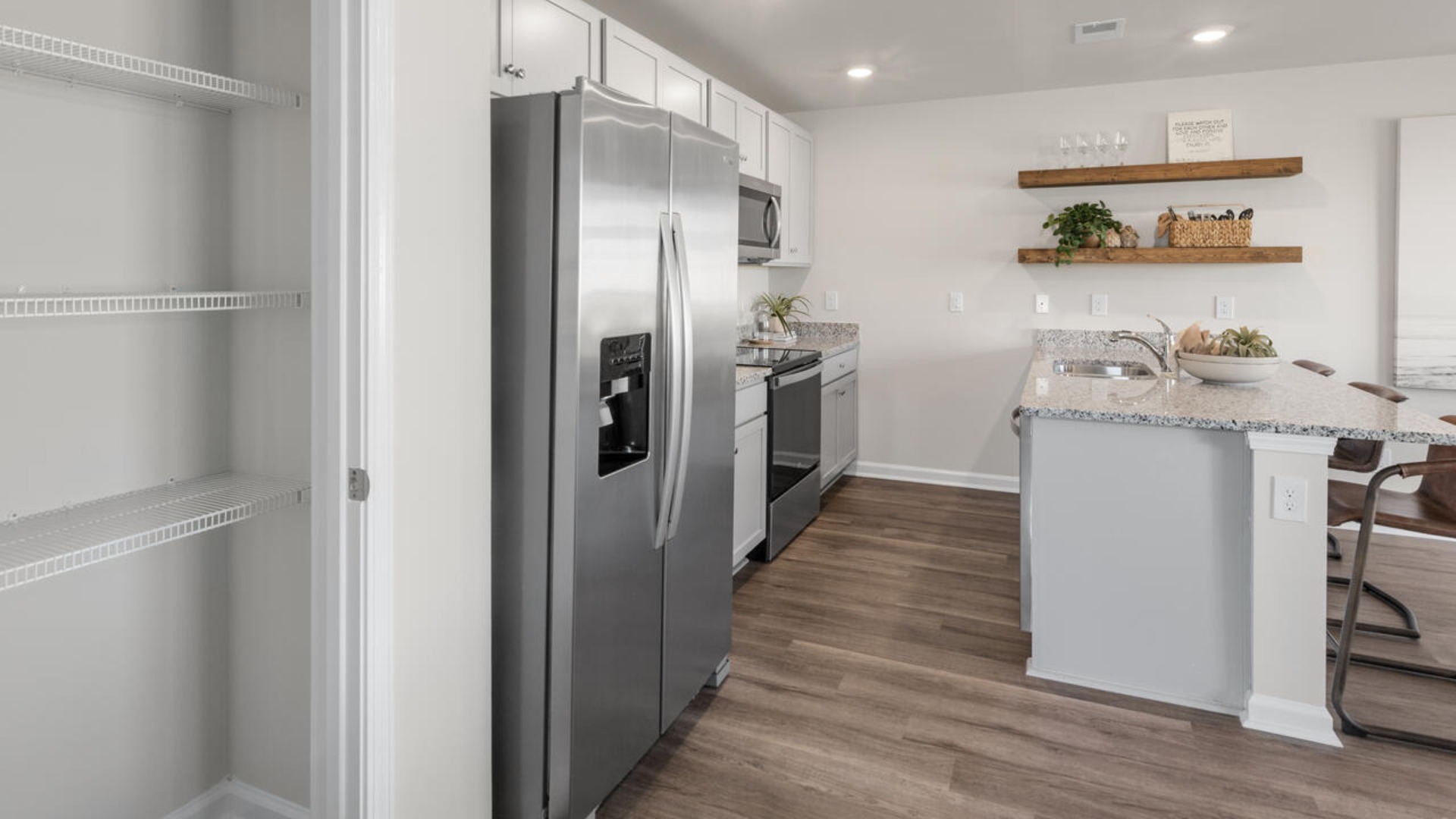 The kitchen features shaker-style cabinets, granite countertops, and stainless steel appliances, which are sure to both turn heads and make meal prep easy. You’ll never be too far from the action with the living and dining area right there.