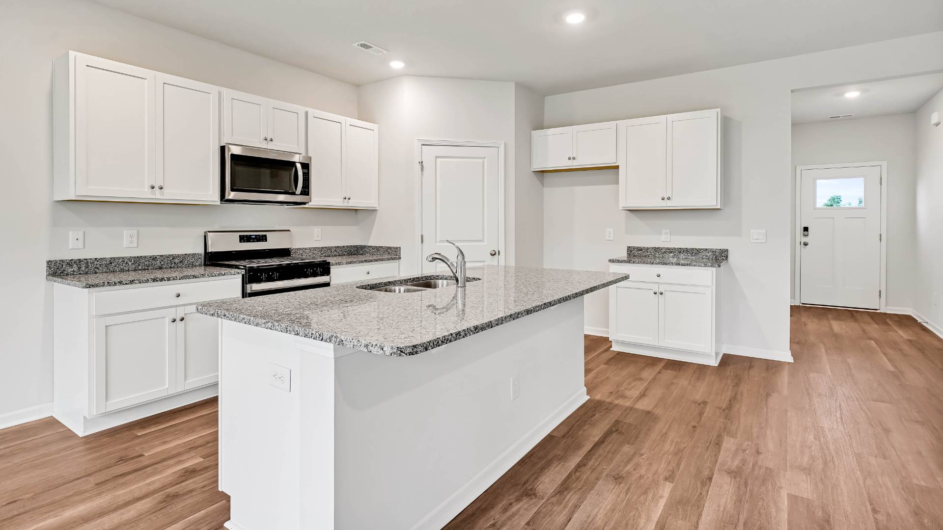 The open-concept kitchen features granite countertops and stainless steel appliances. The kitchen seamlessly connects to the dining and living areas, creating a great space for entertainment