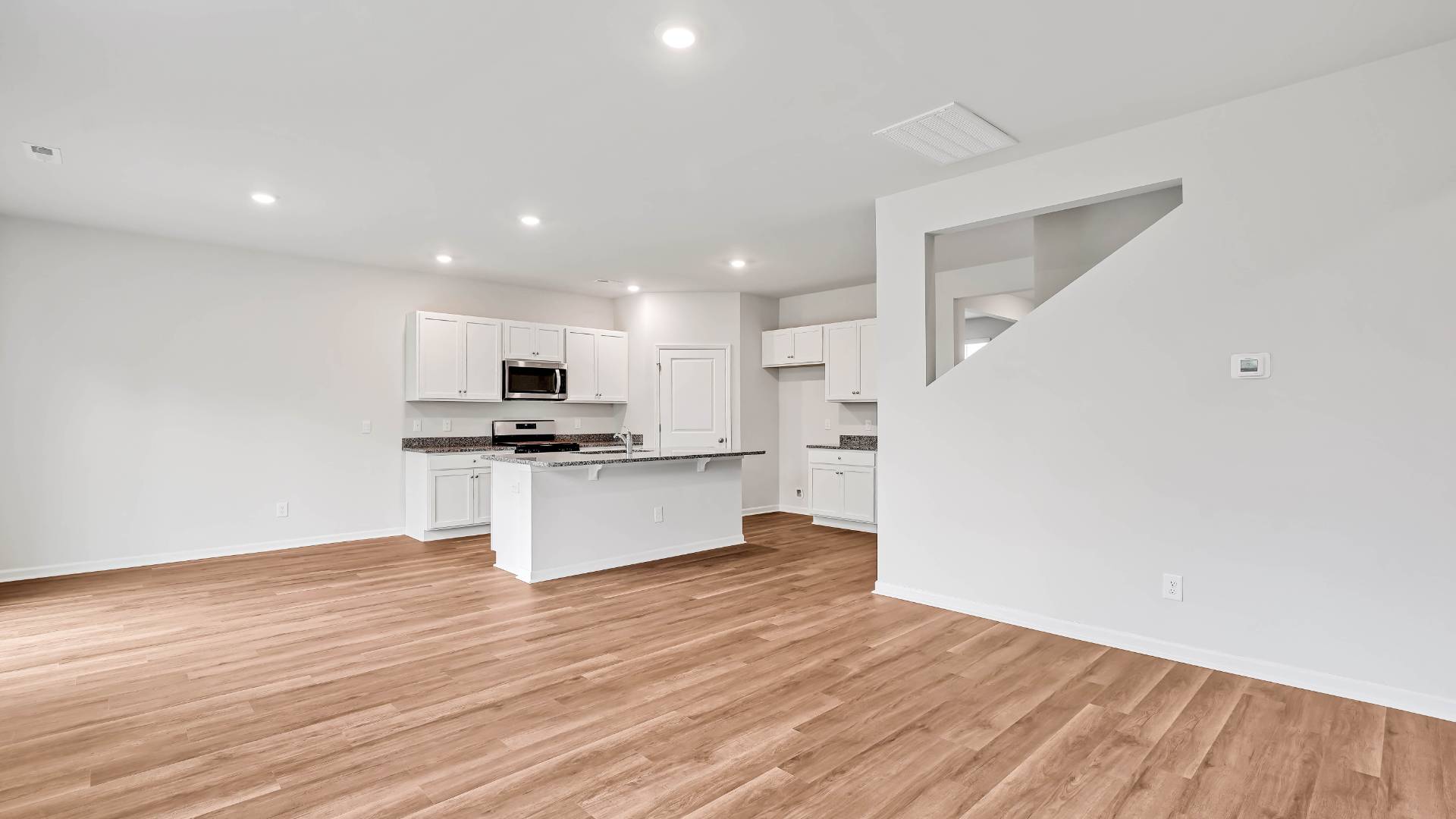The open-concept kitchen features granite countertops and stainless steel appliances. The kitchen seamlessly connects to the dining and living areas, creating a great space for entertainment