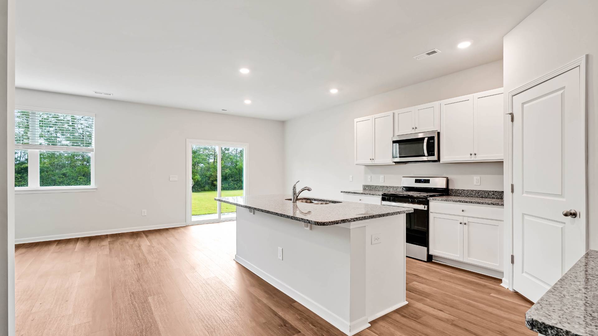 The open-concept kitchen features granite countertops and stainless steel appliances. The kitchen seamlessly connects to the dining and living areas, creating a great space for entertainment
