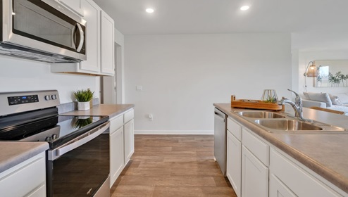 kitchen equipped with Granite countertops, Stainless Steel Appliances, including a smooth-top electric range, microwave, and dishwasher.