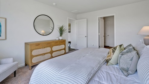 As you enter, you'll find three bedrooms with a shared bathroom, while the Primary Bedroom, off the living area, offers a private ensuite bathroom.
