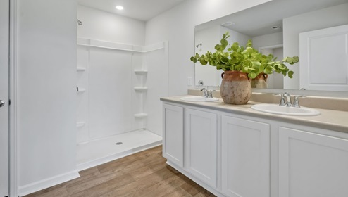 As you enter, you'll find three bedrooms with a shared bathroom, while the Primary Bedroom, off the living area, offers a private ensuite bathroom.