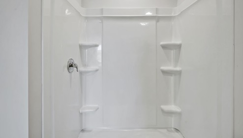 As you enter, you'll find three bedrooms with a shared bathroom, while the Primary Bedroom, off the living area, offers a private ensuite bathroom.