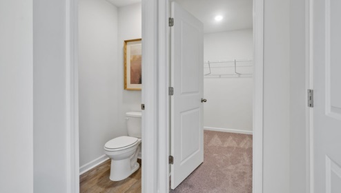 As you enter, you'll find three bedrooms with a shared bathroom, while the Primary Bedroom, off the living area, offers a private ensuite bathroom.