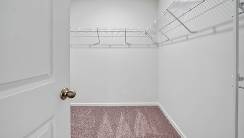 As you enter, you'll find three bedrooms with a shared bathroom, while the Primary Bedroom, off the living area, offers a private ensuite bathroom.