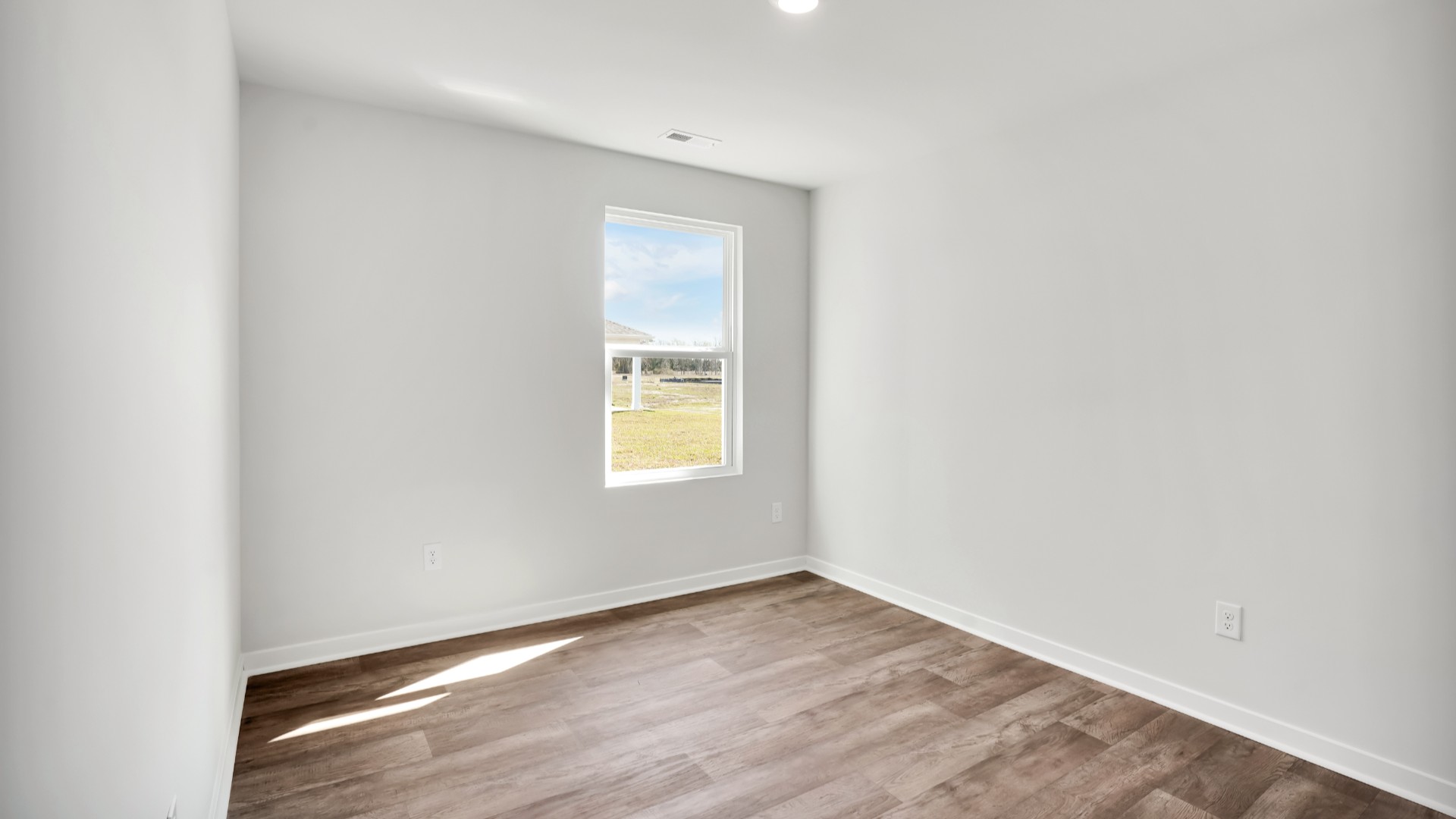 Two other bedrooms share a second bathroom. The laundry room is located at the front of home near the two-car garage, quietly away from living areas and bedrooms. Small covered porch at the front.