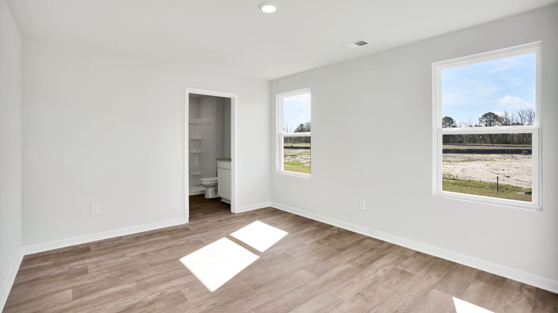 Two other bedrooms share a second bathroom. The laundry room is located at the front of home near the two-car garage, quietly away from living areas and bedrooms. Small covered porch at the front.