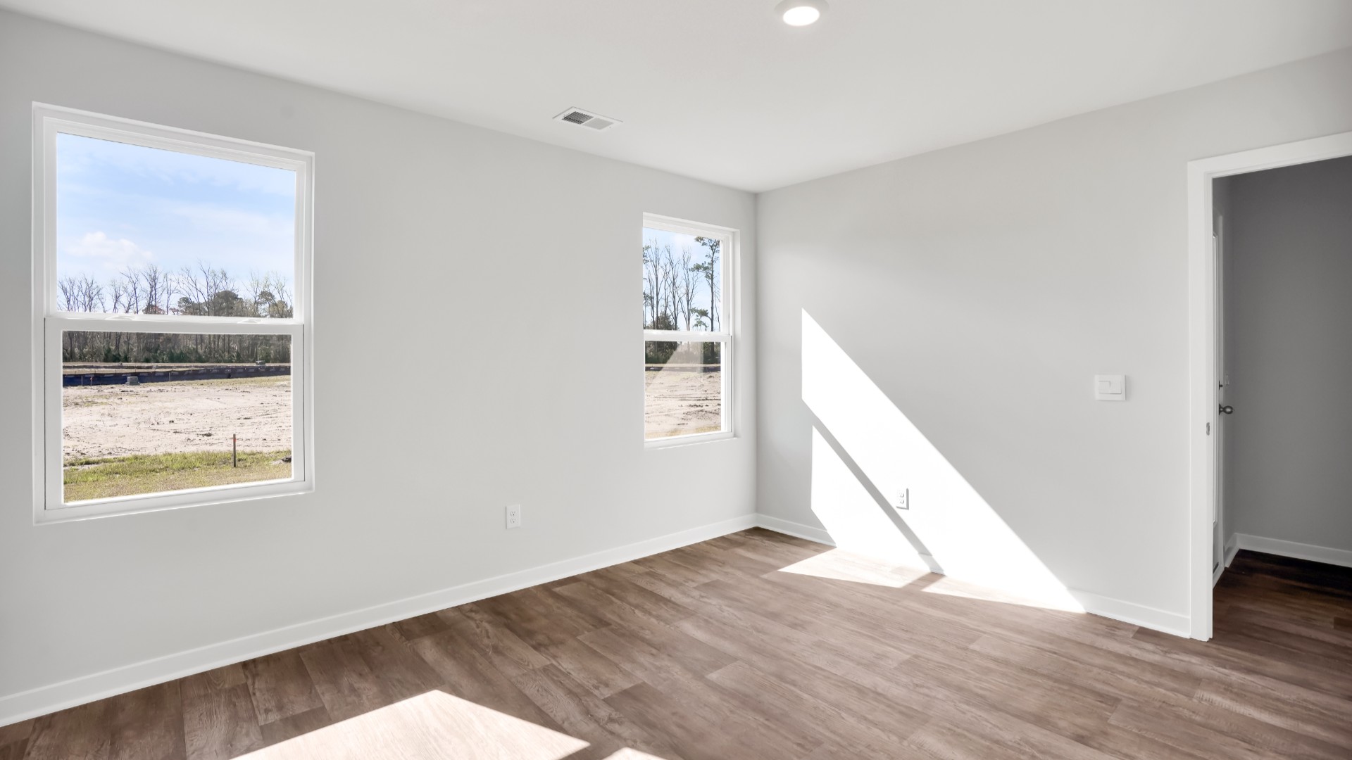 Two other bedrooms share a second bathroom. The laundry room is located at the front of home near the two-car garage, quietly away from living areas and bedrooms. Small covered porch at the front.