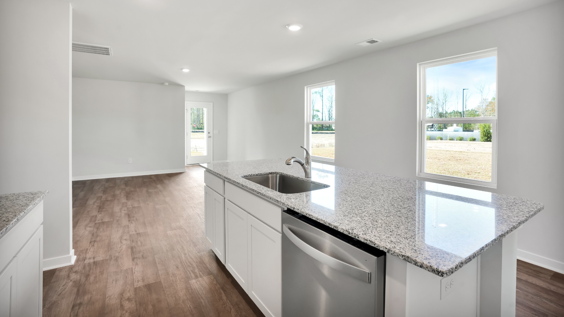 The kitchen features shaker-style cabinets, granite countertops, and stainless-steel appliances, which are sure to both turn heads and make meal prep easy. You’ll never be too far from the action with the living and dining area right there.