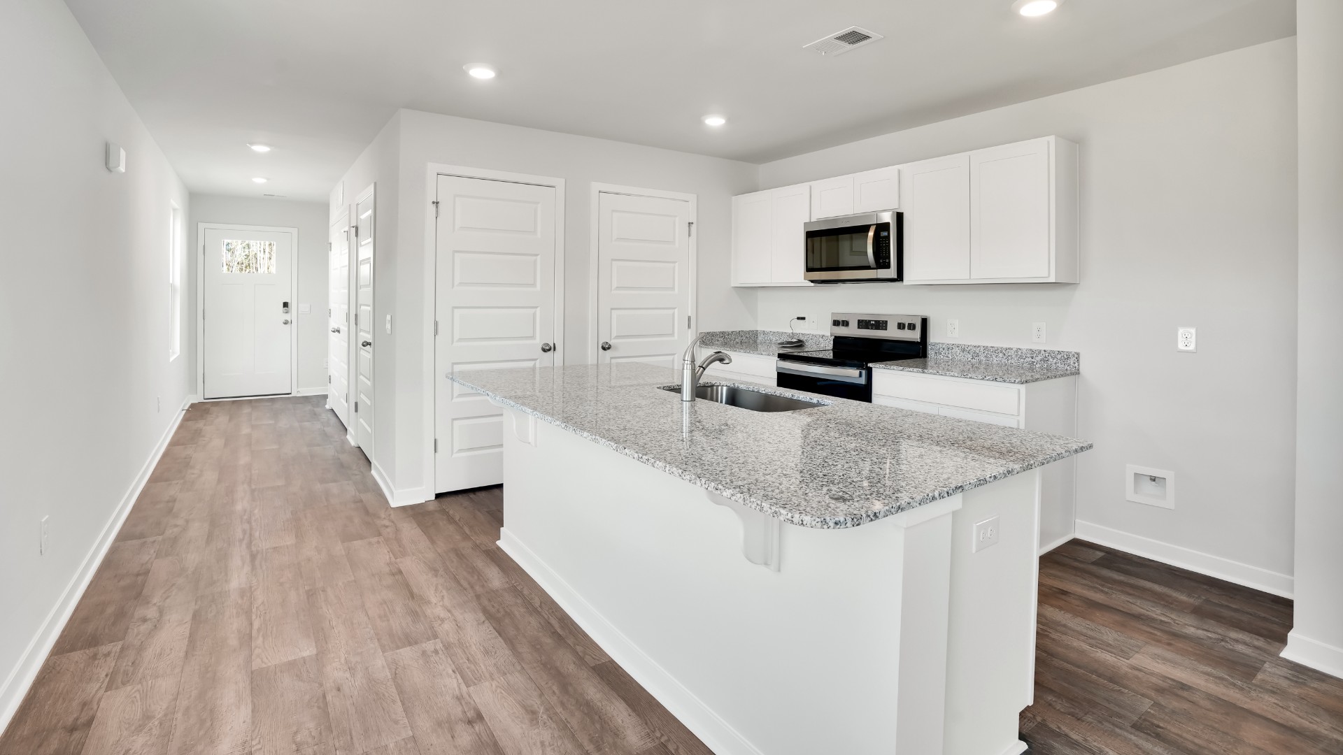 The kitchen features shaker-style cabinets, quartz countertops, and stainless steel appliances, which are sure to both turn heads and make meal prep easy. You’ll never be too far from the action with the living and dining area right there.