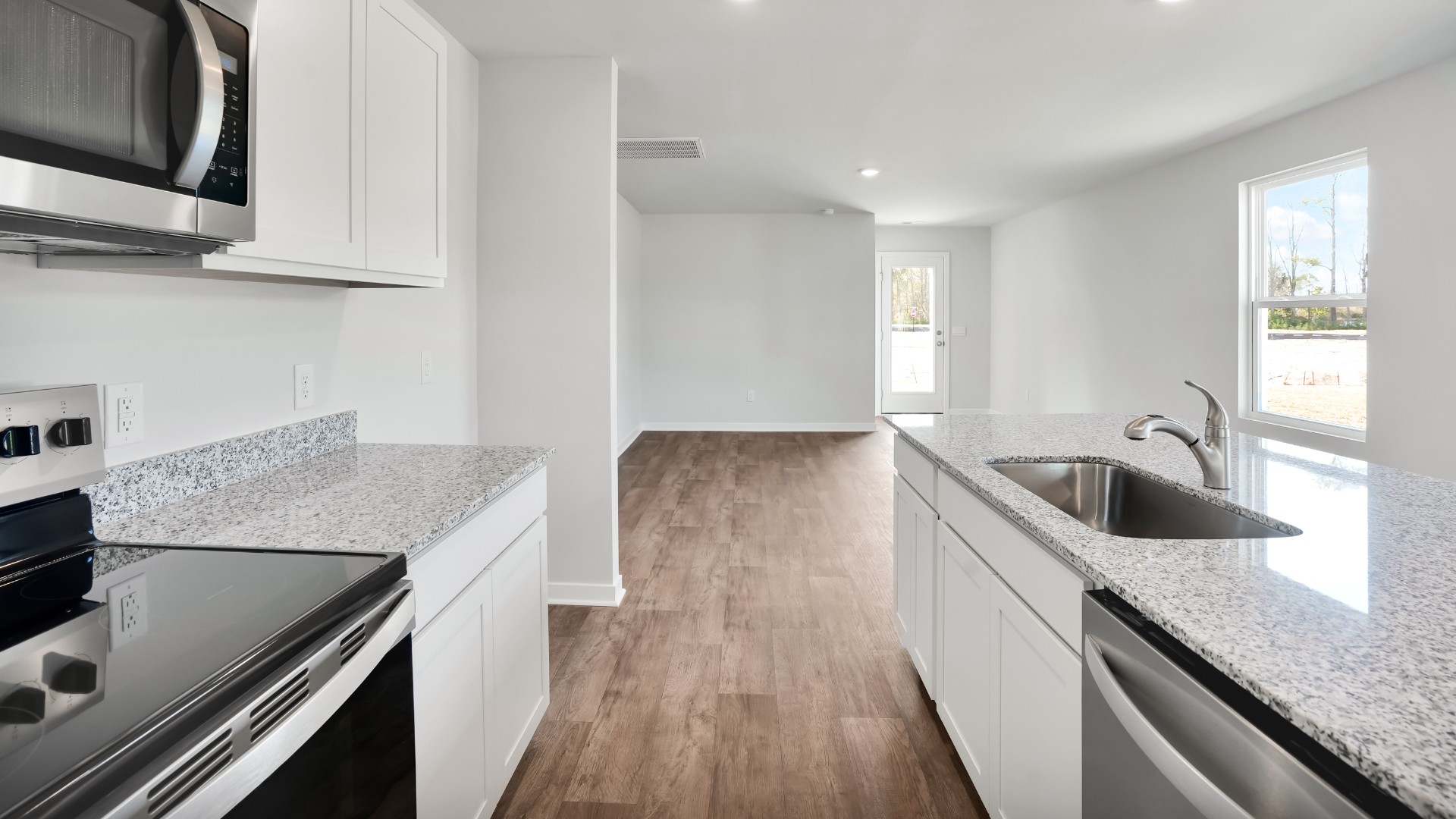 The kitchen features shaker-style cabinets, quartz countertops, and stainless steel appliances, which are sure to both turn heads and make meal prep easy. You’ll never be too far from the action with the living and dining area right there.