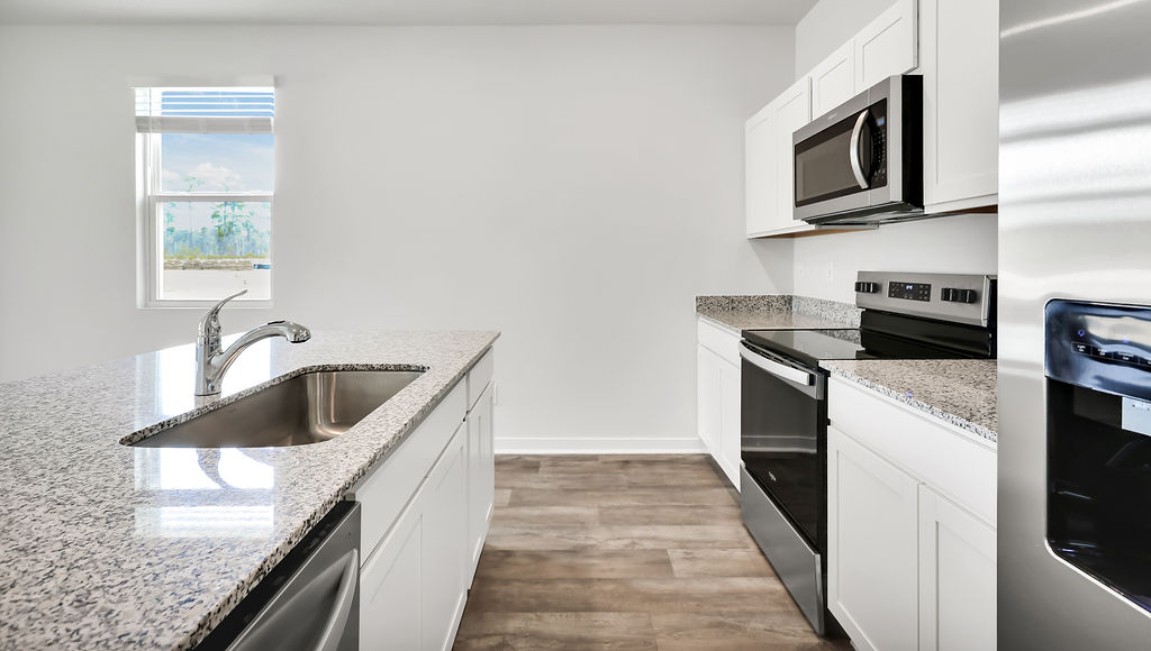 The kitchen features shaker-style cabinets, granite countertops, and stainless steel appliances, which are sure to both turn heads and make meal prep easy