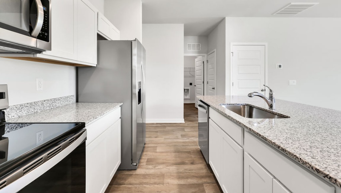 The kitchen features shaker-style cabinets, granite countertops, and stainless steel appliances, which are sure to both turn heads and make meal prep easy