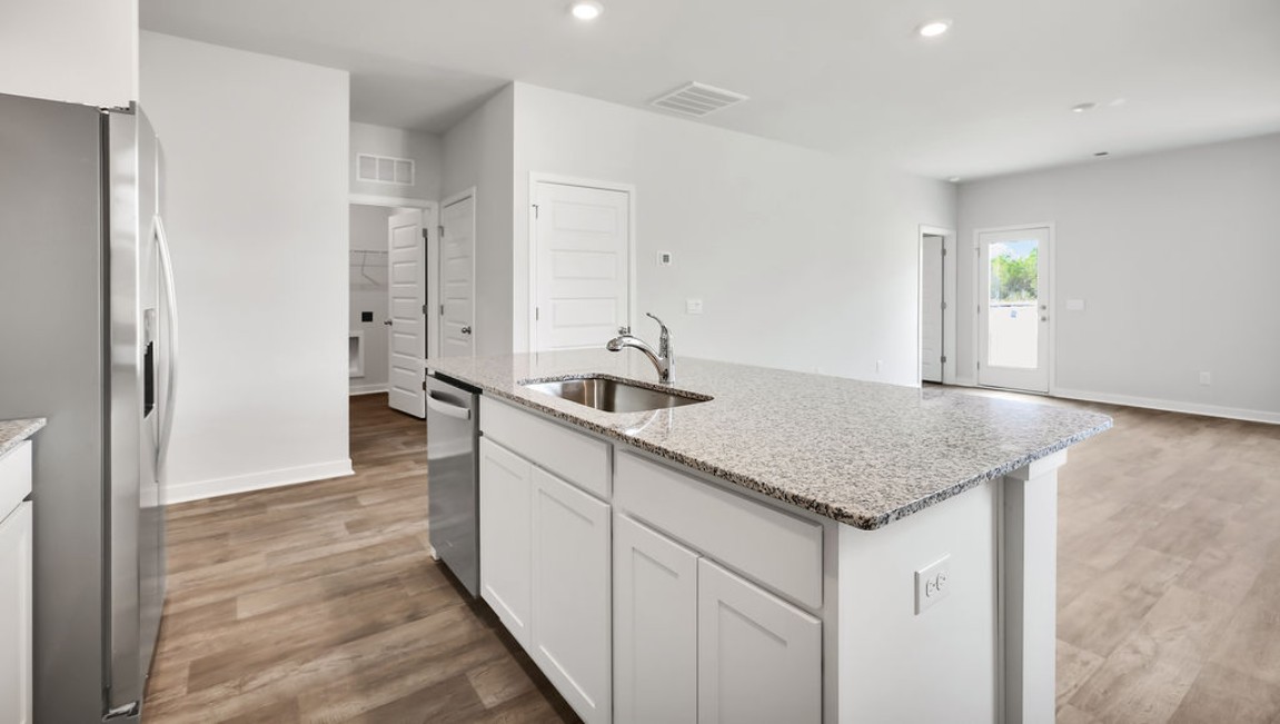 The kitchen features shaker-style cabinets, granite countertops, and stainless steel appliances, which are sure to both turn heads and make meal prep easy