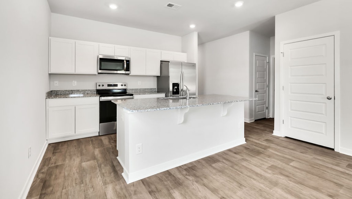 The kitchen features shaker-style cabinets, granite countertops, and stainless steel appliances, which are sure to both turn heads and make meal prep easy