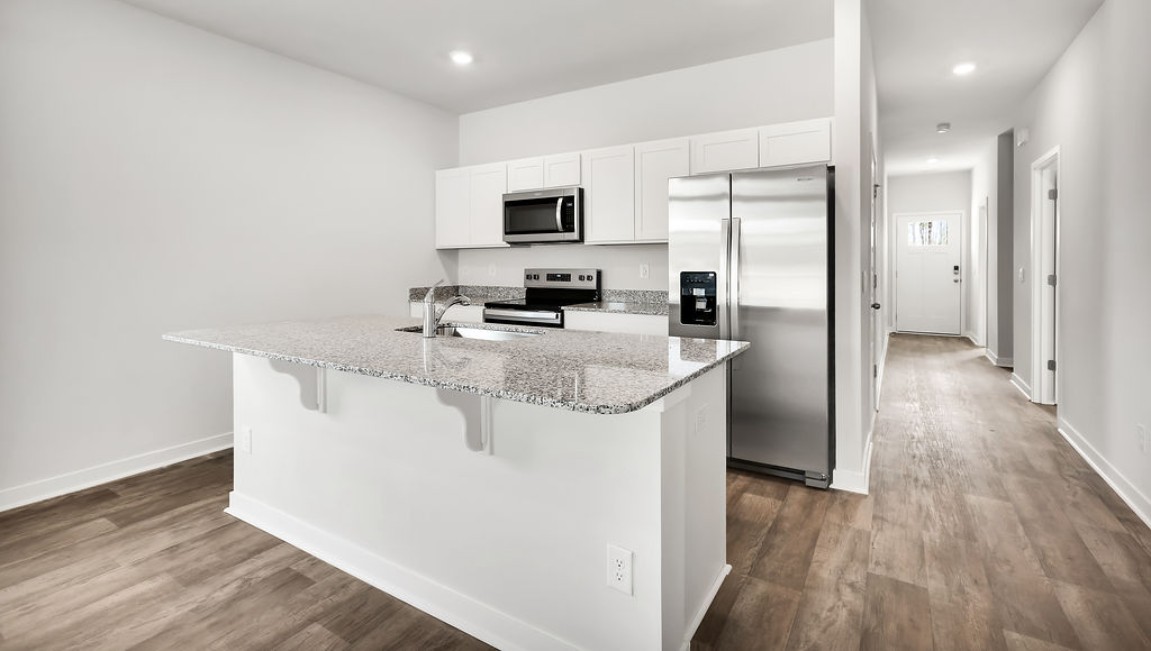 The kitchen features shaker-style cabinets, granite countertops, and stainless steel appliances, which are sure to both turn heads and make meal prep easy