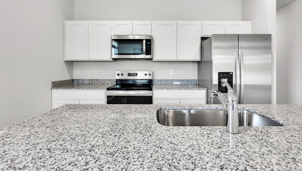 The kitchen features shaker-style cabinets, granite countertops, and stainless steel appliances, which are sure to both turn heads and make meal prep easy