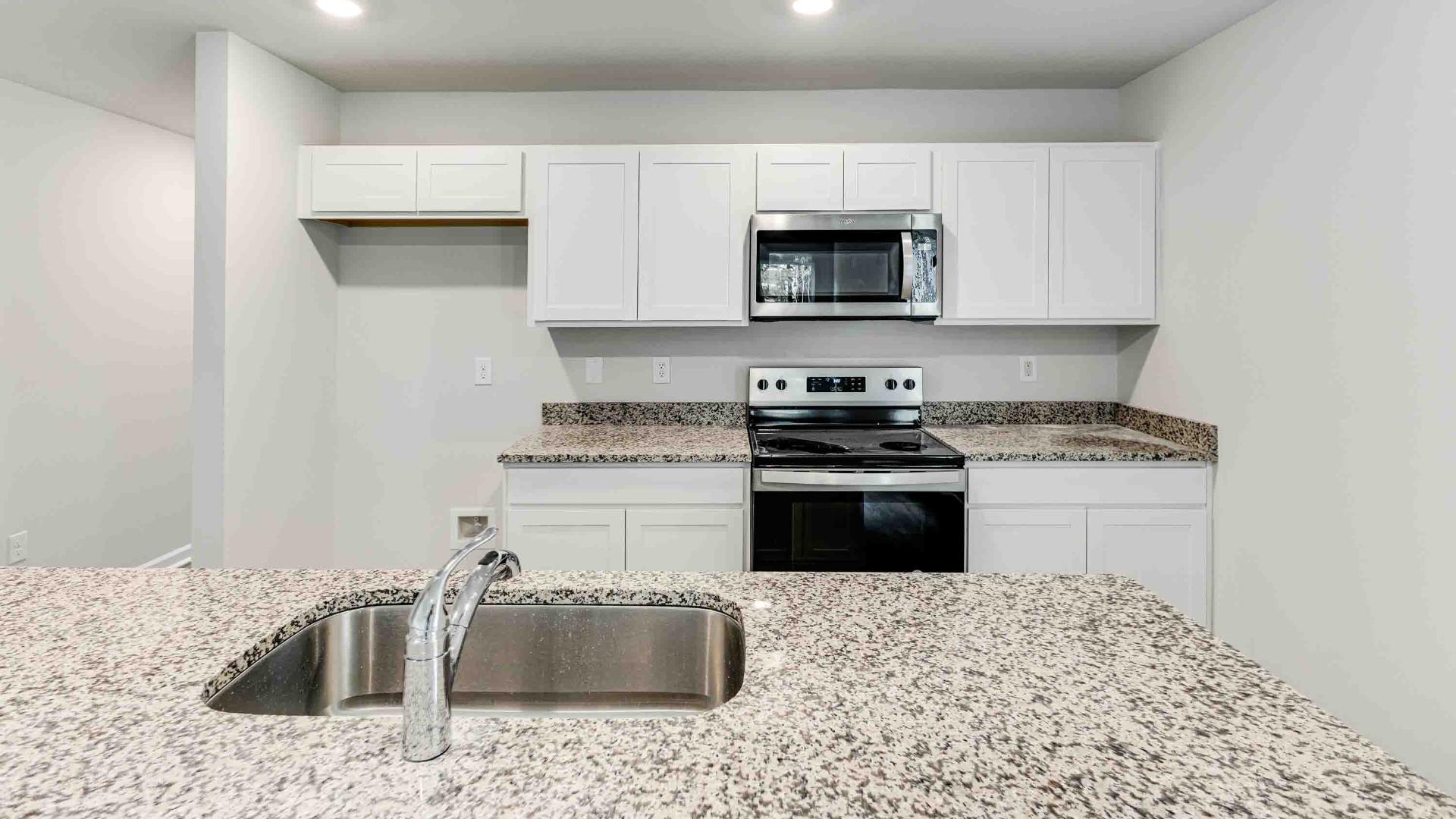 The kitchen features shaker-style cabinets, granite countertops, and stainless steel appliances, which are sure to both turn heads and make meal prep easy. You’ll never be too far from the action with the living and dining area right there.
