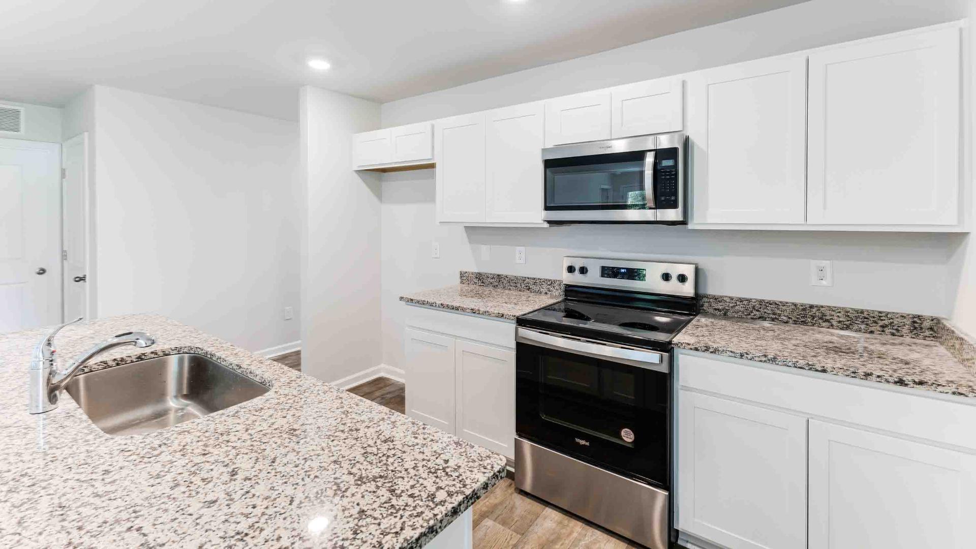 The kitchen features shaker-style cabinets, granite countertops, and stainless steel appliances, which are sure to both turn heads and make meal prep easy. You’ll never be too far from the action with the living and dining area right there.
