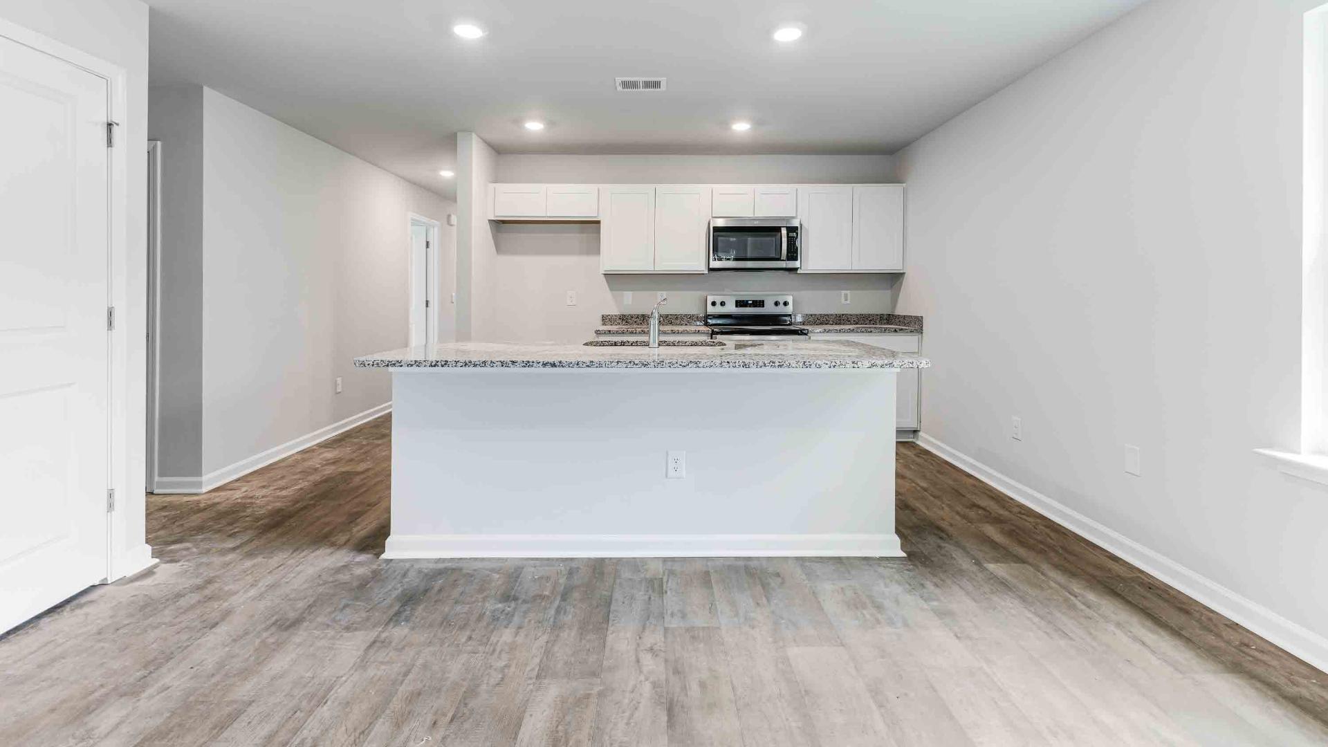 The kitchen features shaker-style cabinets, granite countertops, and stainless steel appliances, which are sure to both turn heads and make meal prep easy. You’ll never be too far from the action with the living and dining area right there.