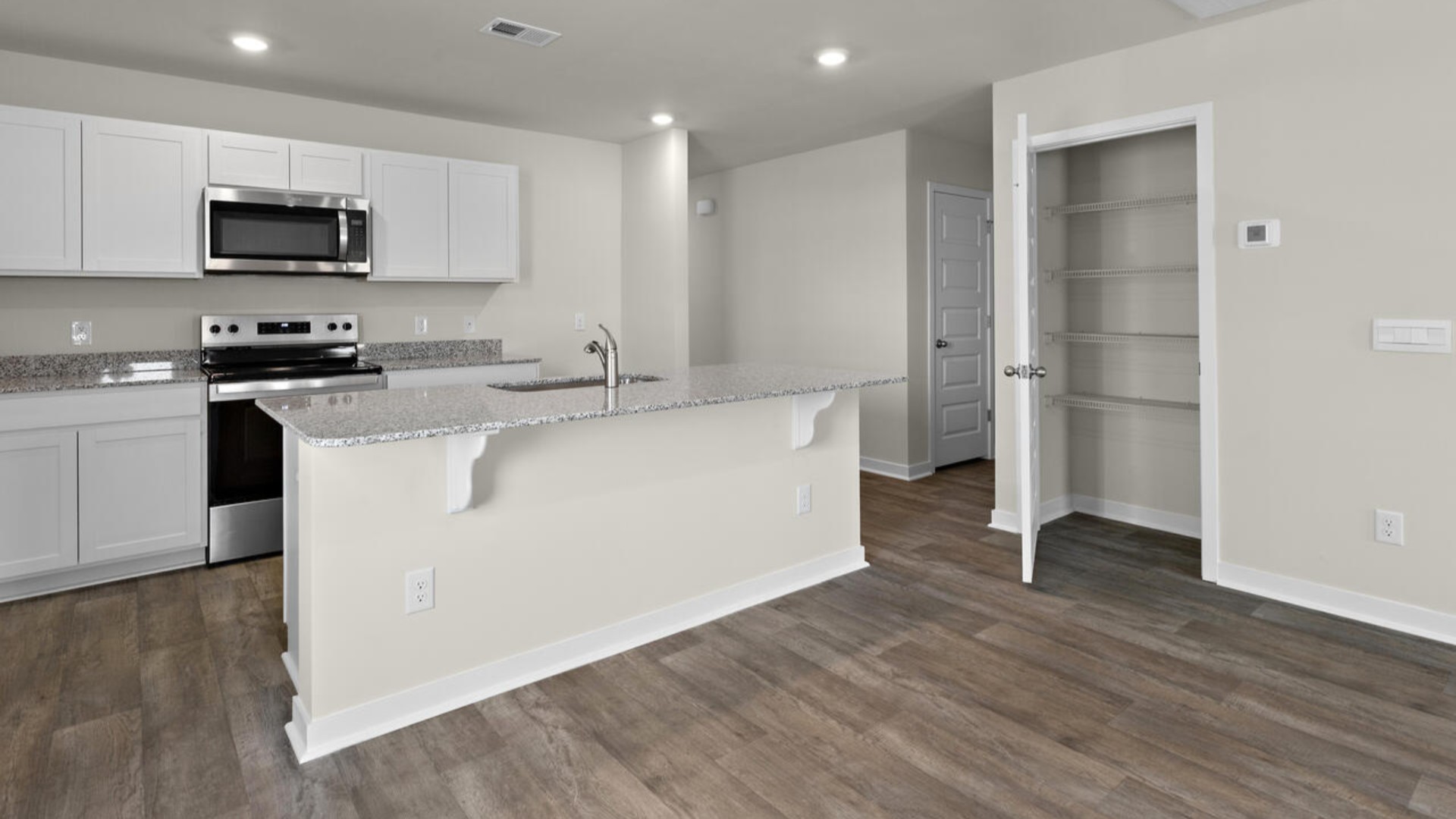 The kitchen features shaker-style cabinets, granite countertops, and stainless steel appliances, which are sure to both turn heads and make meal prep easy.