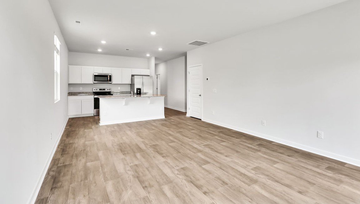 The Devon floor plan offers a spacious open-concept layout that seamlessly connects the living room and kitchen, creating an ideal space for entertaining.