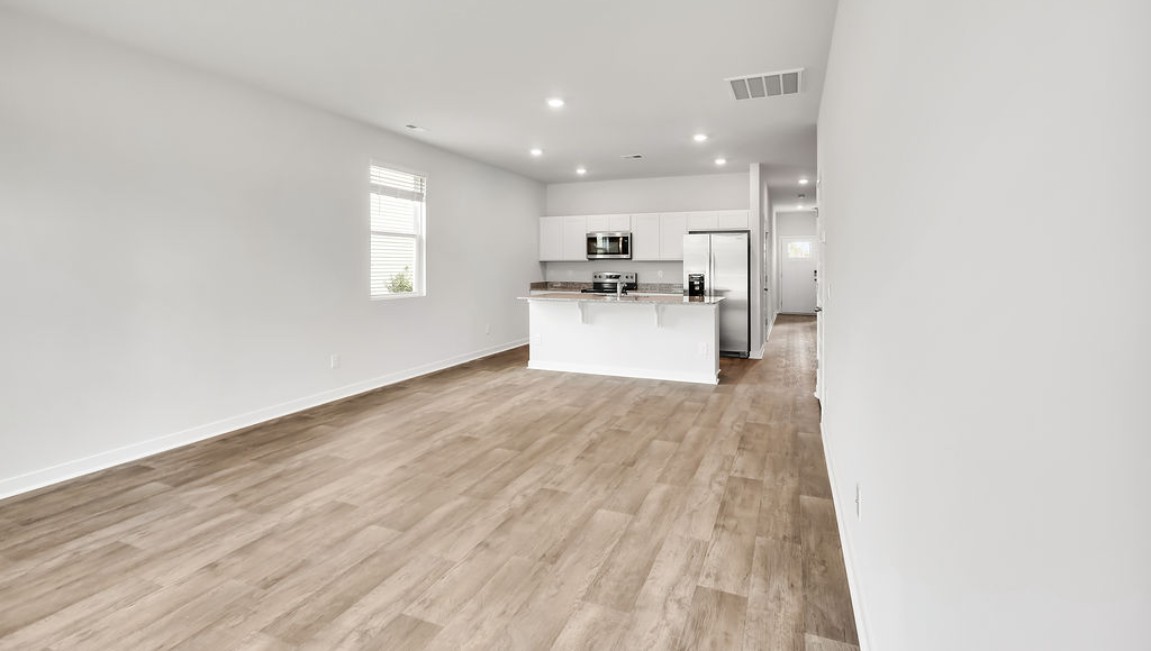 The Devon floor plan offers a spacious open-concept layout that seamlessly connects the living room and kitchen, creating an ideal space for entertaining.