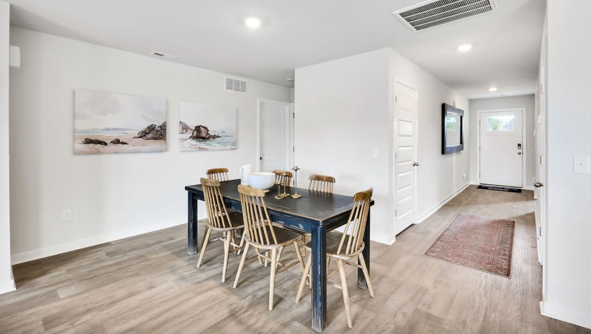 The open-concept family room, kitchen, and dining area feature granite countertops, stainless steel appliances, including a smooth-top range, dishwasher, and overhead microwave.