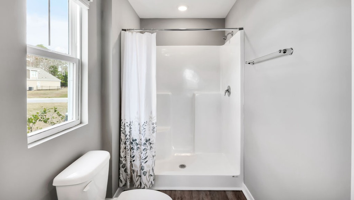 At the back, the Primary Suite provides privacy with a large walk-in closet and walk-in shower. This floor plan combines comfort and convenience