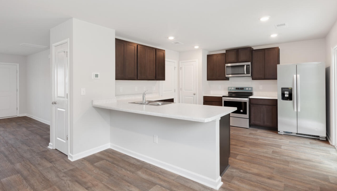 The kitchen features shaker-style cabinets, quartz countertops, and stainless steel appliances, which are sure to both turn heads and make meal prep easy. You’ll never be too far from the action with the living and dining area right there.