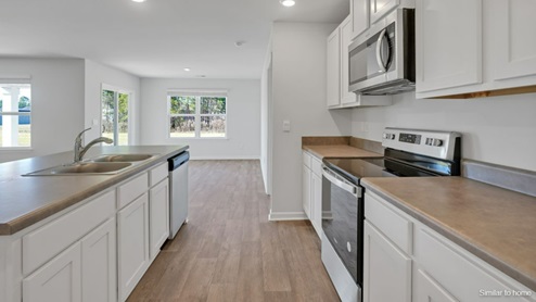 The spacious kitchen offers plenty of cabinet and counter space with a large pantry and stainless steel appliances.