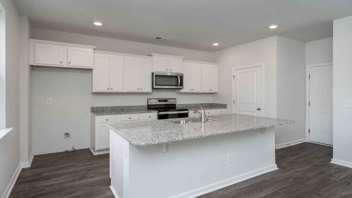 The kitchen features stainless steel appliances, granite countertops an extra-large pantry, a lot of cabinet space, and an efficient layout that is open to the dining and family room.