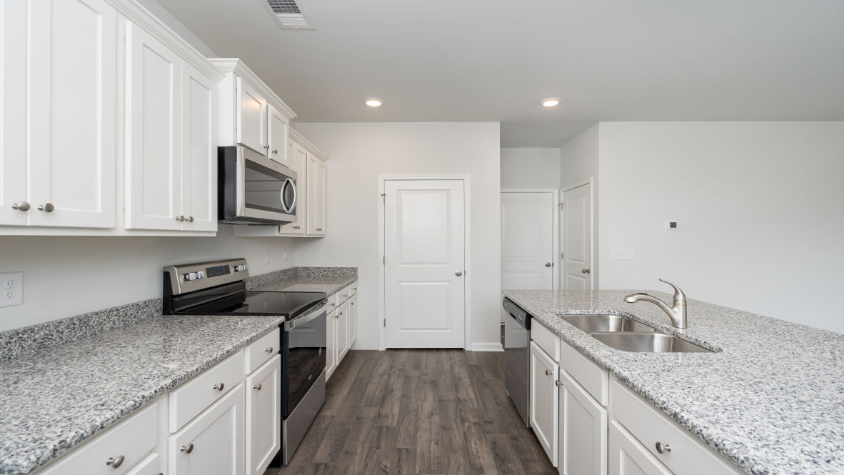The kitchen features stainless steel appliances, granite countertops an extra-large pantry, a lot of cabinet space, and an efficient layout that is open to the dining and family room.