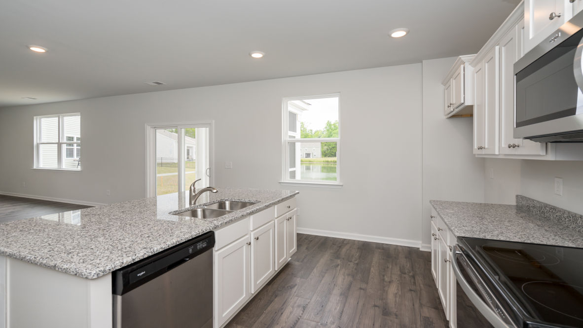 The kitchen features stainless steel appliances, granite countertops an extra-large pantry, a lot of cabinet space, and an efficient layout that is open to the dining and family room.