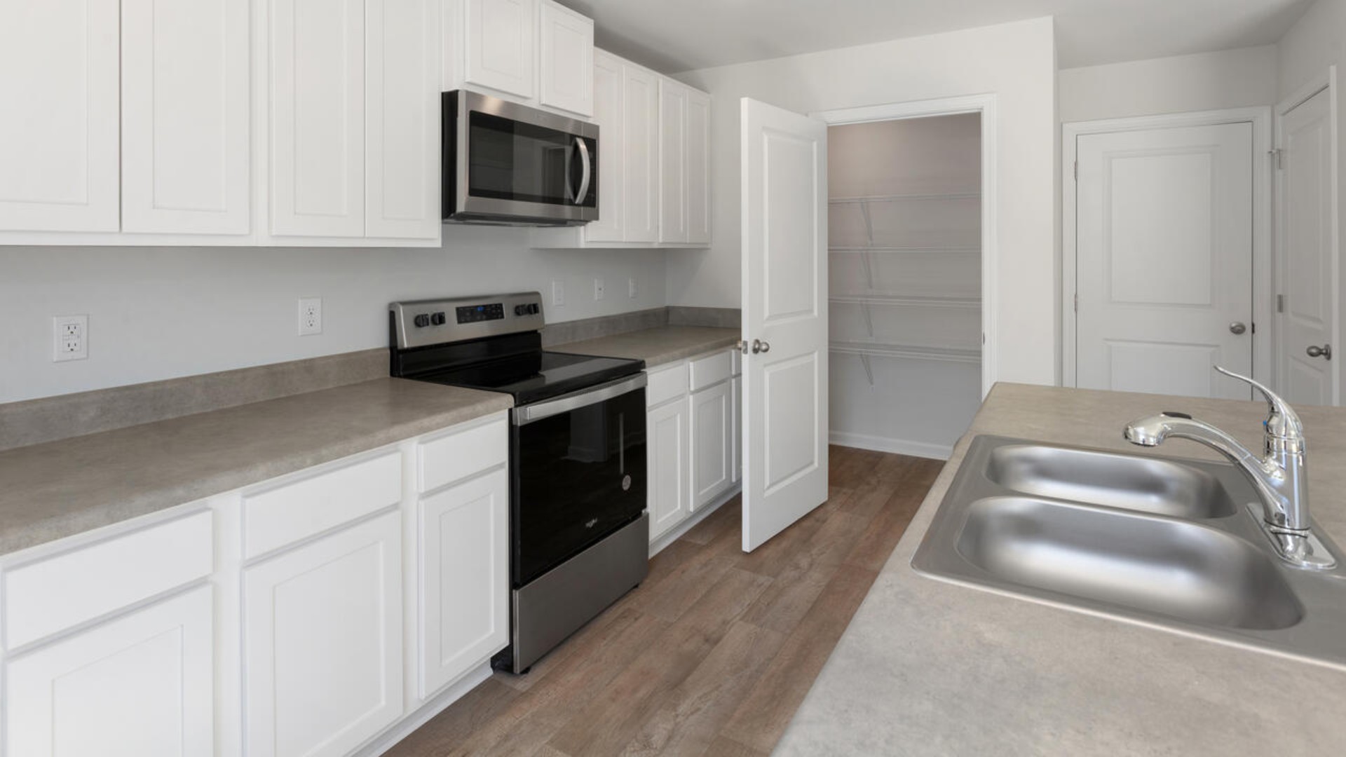 The kitchen features stainless steel appliances, granite countertops an extra-large pantry, a lot of cabinet space, and an efficient layout that is open to the dining and family room. The kitchen island is the perfect size for meal prep with a built-in sink and dishwasher.