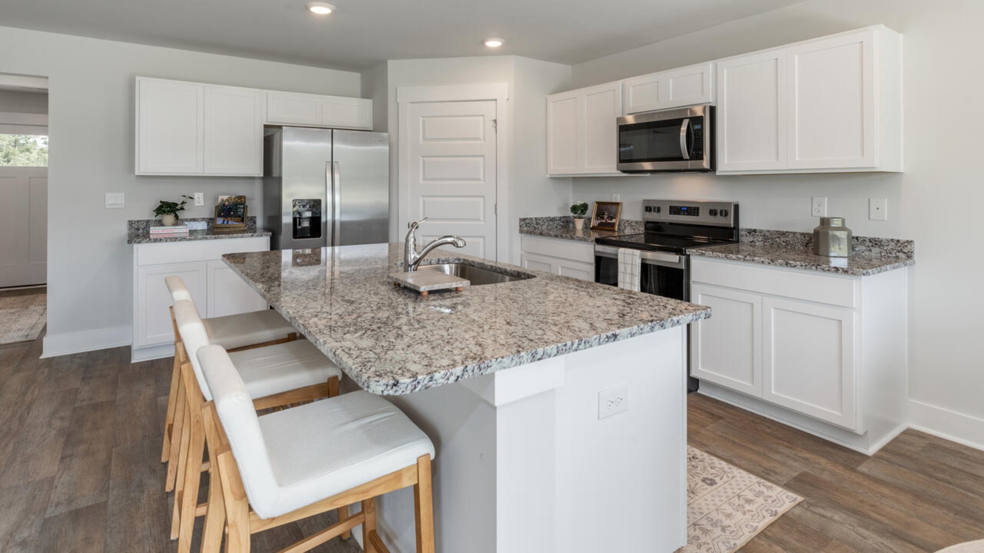 The open-concept kitchen features granite countertops and stainless steel appliances. The kitchen seamlessly connects to the dining and living areas, creating a great space for entertainment.