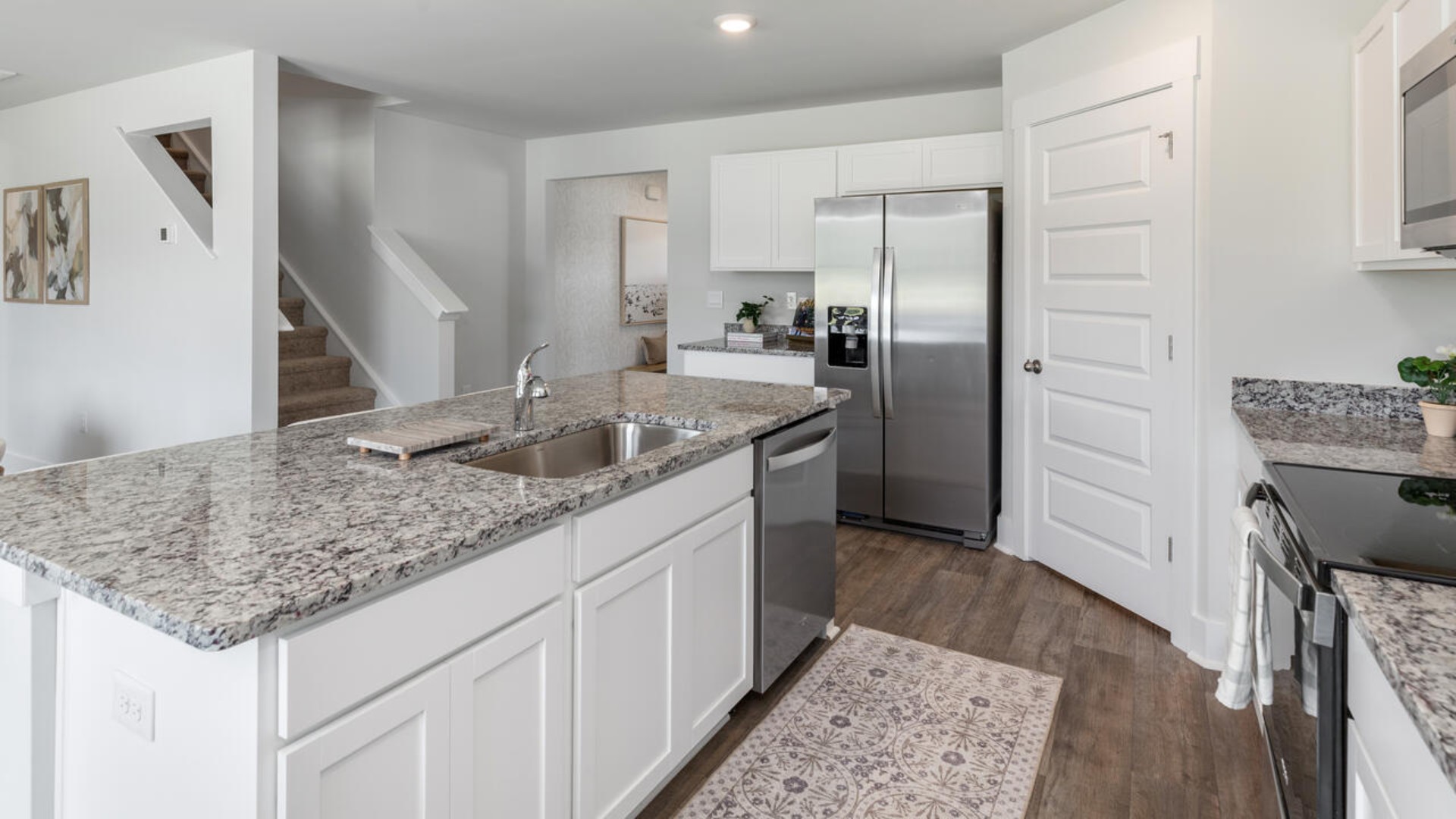 The open-concept kitchen features granite countertops and stainless steel appliances. The kitchen seamlessly connects to the dining and living areas, creating a great space for entertainment.