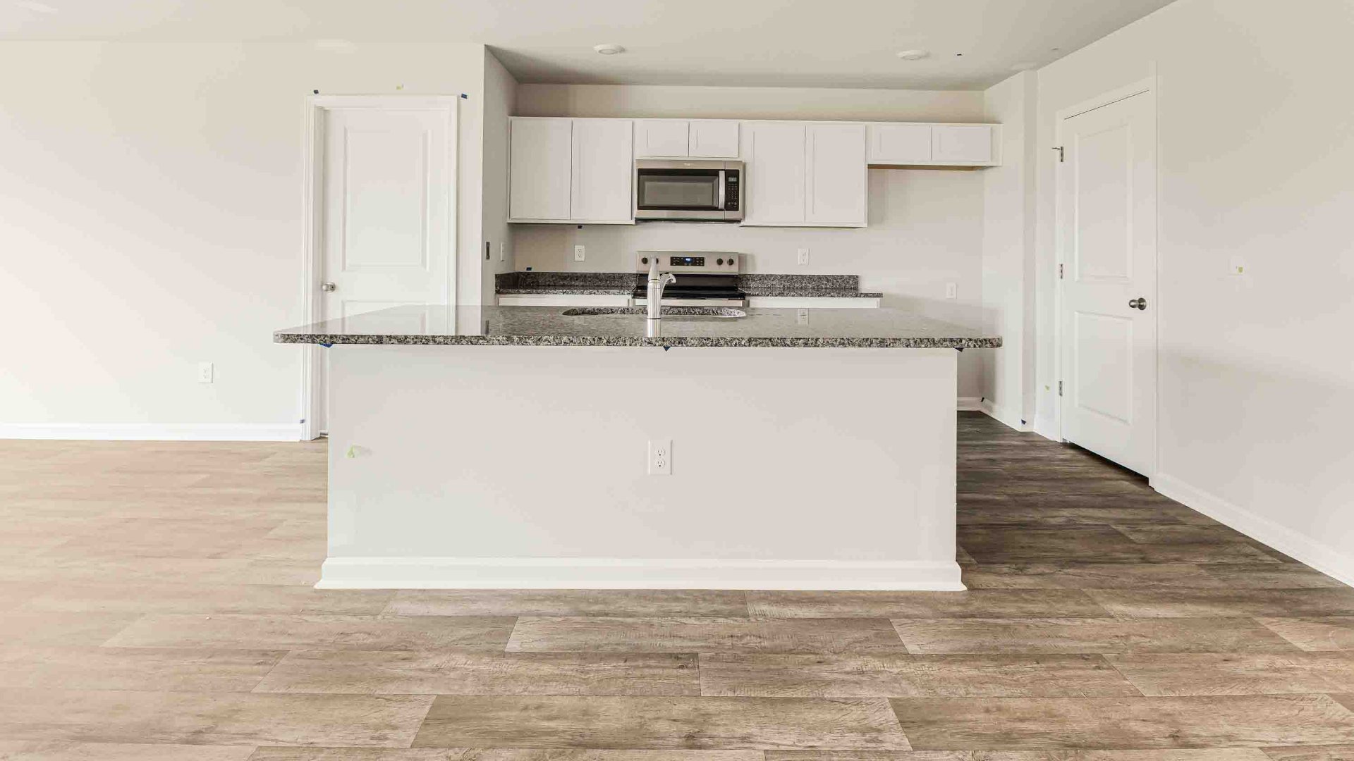 The kitchen features a large island, granite countertops, and stainless-steel appliances, which are sure to both turn heads and make meal prep easy. You’ll never be too far from the action with the living and dining area right there.